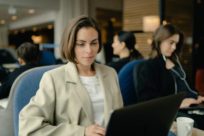 En kvinna med en dator som sitter på en flygplats